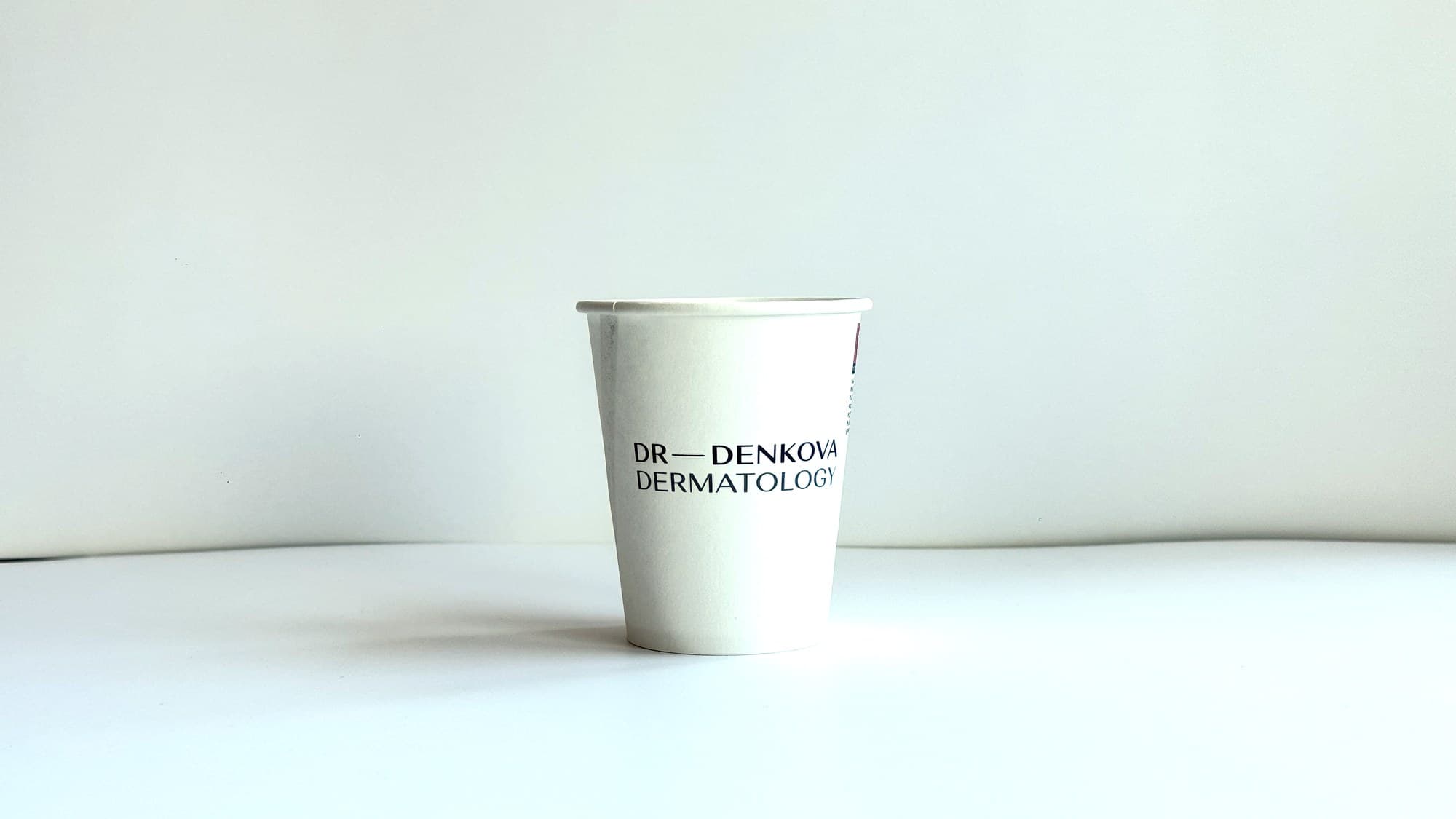 Бяла картонена чаша с надпис Dr Denkova Dermatology